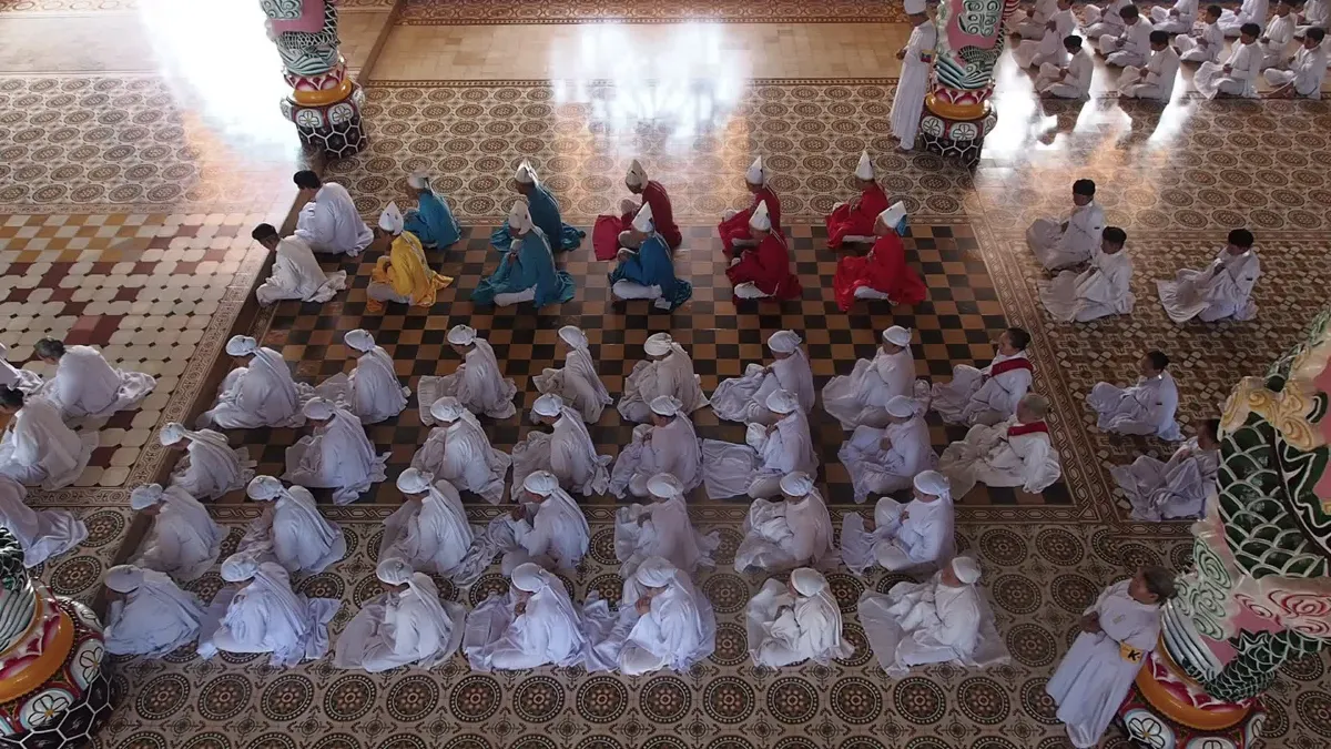 Cao Dai followers in white robes during the noon ceremony at the Tay Ninh Holy See