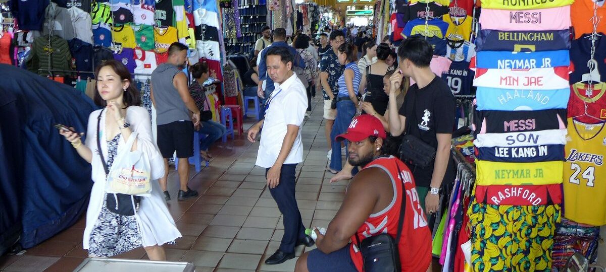 Shoppers among food and souvenir stalls inside Ben Thanh Market, Ho Chi Minh City