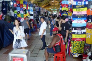 Shoppers among food and souvenir stalls inside Ben Thanh Market, Ho Chi Minh City