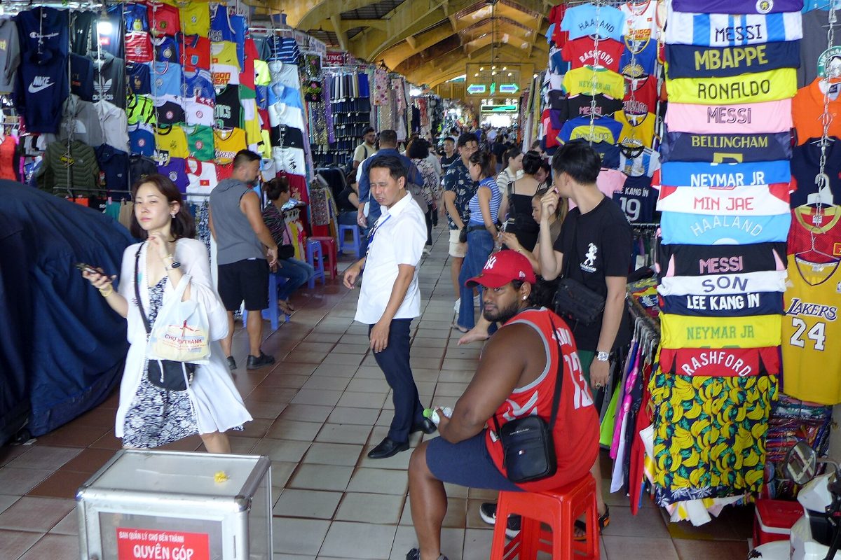 Shoppers among food and souvenir stalls inside Ben Thanh Market, Ho Chi Minh City