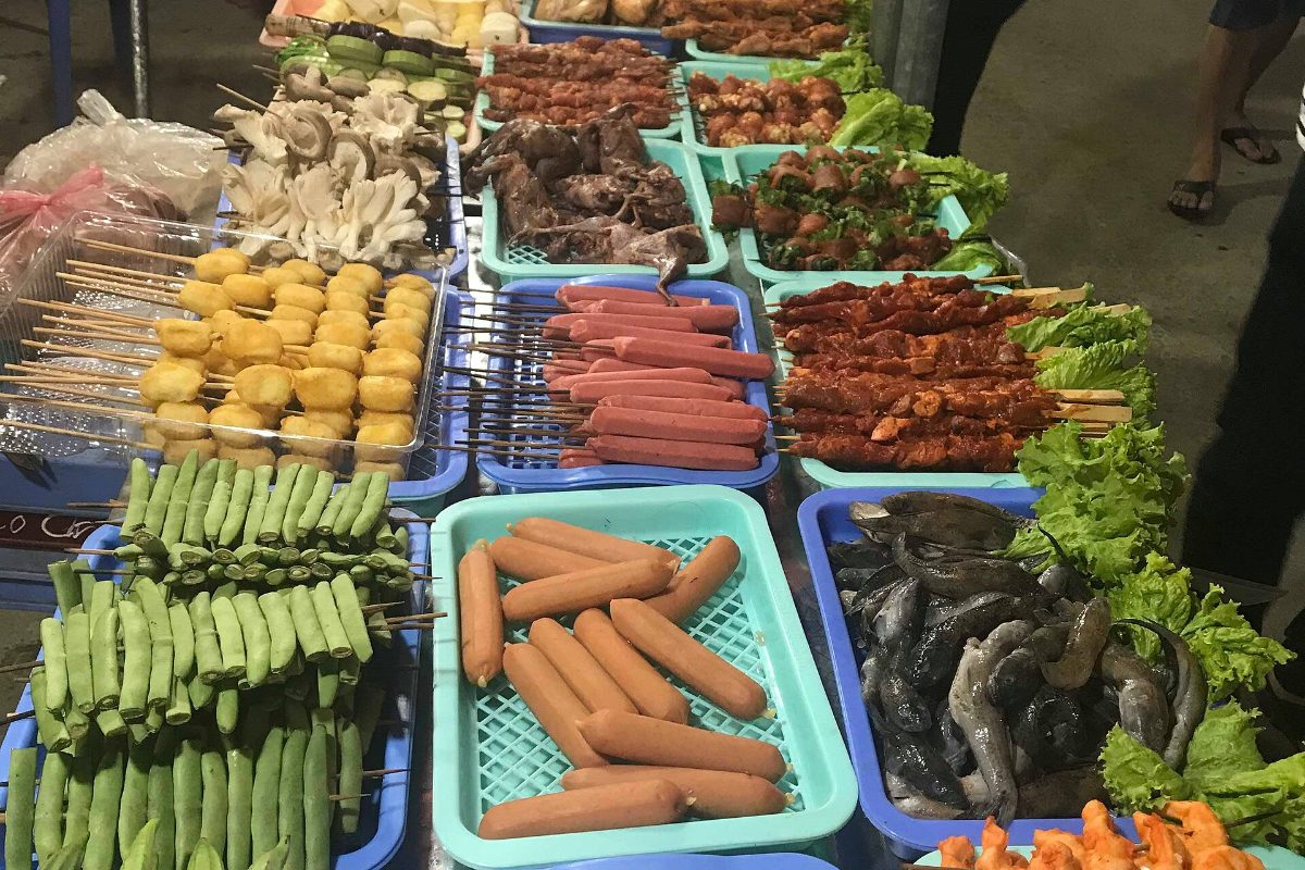 Trays of grilled skewers and sausages at a Sapa street food stall